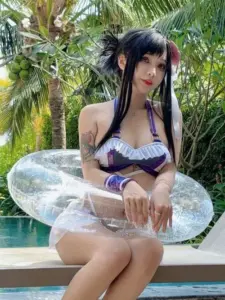 Cô nàng tóc đen ngồi trong phao trong suốt, bikini tím nổi bật giữa vườn nhiệt đới