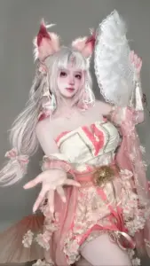 Nàng cosplayer nghiêng đầu cười nhẹ, tay cầm tai nghe game và mắt nhìn thẳng vào ống kính