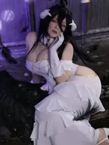 Cô gái tóc đen ngồi dưới ánh tím, bộ đồ trắng tím khoe dáng cosplay bắt mắt