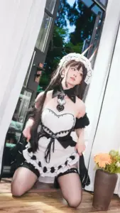 Người mẫu váy maid đen trắng quỳ bên cửa kính, nụ cười quyến rũ và rất mềm