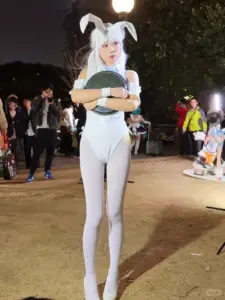 Dáng ngồi mềm mại của cosplayer tóc xanh nổi bật với váy xanh trắng và tất lưới