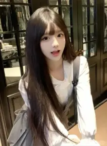 Ánh đèn vàng phủ lên nàng tóc dài áo trắng, nét ngọt ngào toát ra khi ngồi