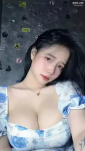 Trên ga giường xanh, cô nàng áo hoa xanh trắng nghiêng đầu nhìn thẳng rất duyên.