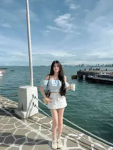 Dáng đứng tự nhiên trên bến cảng áo xanh chân váy trắng tạo cảm giác tươi mát