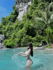 Giữa vịnh nước ngọc, dáng đứng quay lưng trong bikini sáng màu hòa cùng núi đá xanh