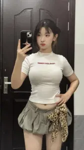 Trước cánh cửa tối, cô nàng sexy mặc áo trắng chân váy ngắn tạo dáng selfie tự tin