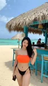 Quầy bar ven biển, cô gái Korea diện bikini cam đen đứng, tóc dài xõa tự nhiên