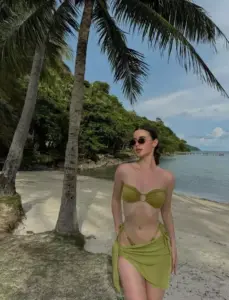 Tán cọ ven biển, cô nàng mặc bikini xanh lá, kính râm tạo dáng thoải mái