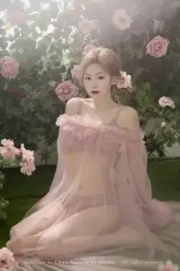 Nàng tóc vàng ngồi giữa vườn hoa, đầm ngủ hồng mỏng tạo vẻ mơ màng dịu mắt