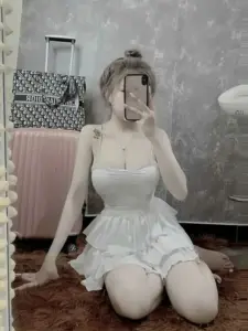 Tư thế quỳ nhẹ làm hot girl váy trắng thêm duyên, bối cảnh xám tạo nét dịu