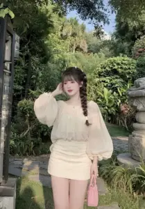 Giữa khu vườn xanh bạn nữ diện áo tay phồng cùng chân váy kem thanh thoát