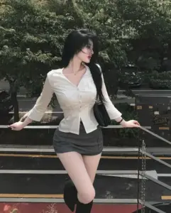 Trên lối đi ven hồ, cô gái áo trắng quần short đen bước nhẹ giữa hàng cây