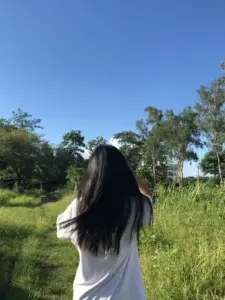 Góc chụp sau lưng cô gái mặc váy hoa, khung cảnh vườn xanh tạo vibe trong trẻo