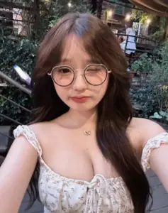 Giữa quán nhỏ, người đẹp đeo kính tròn selfie với áo hoa trễ vai nhẹ nhàng