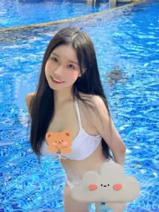 Trong làn nước xanh, gái xinh Tiktok mặc bikini trắng cười dịu dàng với phao hoa