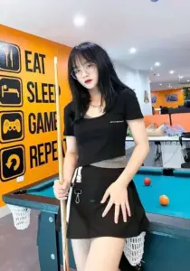 Nàng mặc váy đen ở phòng bida tạo dáng cạnh bàn cơ với nữ streamer xinh xắn