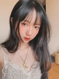 Cận mặt trong nhà, cô nàng tóc đen buông vai, môi hồng và vòng cổ nhỏ