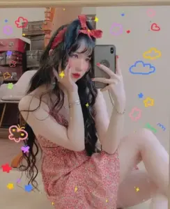 Trong khung tự chụp trang trí, cô nàng mặc váy cam, má hồng cùng tóc uốn