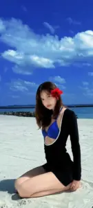 Bầu trời xanh sau làm nổi dáng quỳ của mẫu nữ trong đồ bơi đen kiểu Lalisa