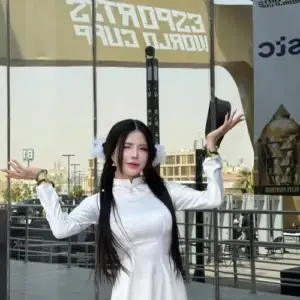 Tại khu sự kiện, visual Gen Z mặc váy trắng bó nhẹ, hai tay bám khung cửa