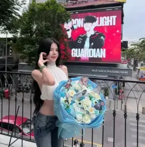 Giữa phố đông, cô gái ôm bó hoa xanh lớn, outfit đen trắng tạo nét tươi tắn