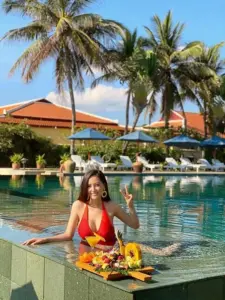 Giữa hồ xanh và hàng dừa, cô gái bikini cam cười tươi trên khay nổi rực nắng