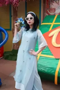Nụ cười hot girl game thủ trong áo dài xanh nhạt, kính đen tạo vẻ duyên dáng