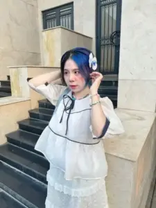 Tấm hình nàng thơ cosplay ngồi trên bậc thềm, váy trắng và tai nghe nhìn cực xinh