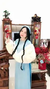 Dáng đứng dịu dàng bên bàn thờ Tết, áo trắng váy xanh tạo nét nữ tính
