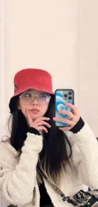 Chiếc mũ đỏ nổi bật ảnh selfie gương, cô gái mặc áo len trắng nhìn tinh nghịch
