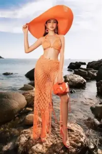 Dưới mũ rộng vành cam, Thùy Tiên tạo dáng bên ghềnh đá, bikini ren rực rỡ