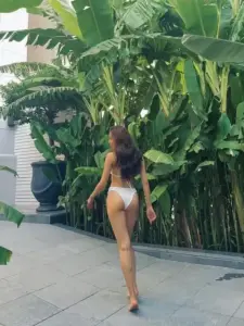 Trước hàng chuối xanh, cô nàng bước nhẹ trong bikini vàng nhạt, dáng cao và tóc dài