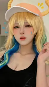 Cô nàng cosplay Free Fire ngồi trên ghế gaming, áo khoác trễ vai nhẹ và biểu cảm cực cuốn
