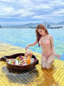 Trên hồ bơi vô cực, hot girl Việt mặc bikini sáng màu, quỳ cạnh khay trái cây nổi bật