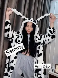 Nền xanh nhạt làm nổi cô kéo tai áo bò sữa, biểu cảm tinh nghịch
