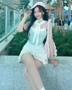 Bên khung cửa kính xanh, nàng ngồi thả dáng với đầm trắng và áo khoác mint