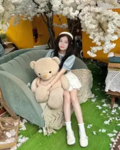 Trong góc phòng hoa trắng, nữ streamer Sammy Đào ôm gấu bông, diện váy sáng màu