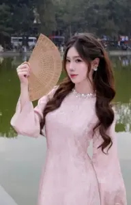 Chiếc nón lá làm bóng dáng áo dài hồng thêm duyên, gương mặt nhìn nghiêng dịu dàng