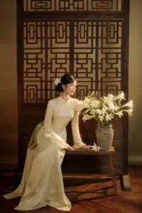 Phố cổ buổi sớm ôm cô gái mặc áo dài trắng cười nhẹ bên tường vàng cũ