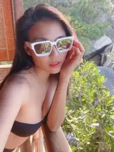 Khoảnh khắc cận mặt bên hiên nhà cho thấy kính trắng nổi bật và áo bikini đen gợi cảm