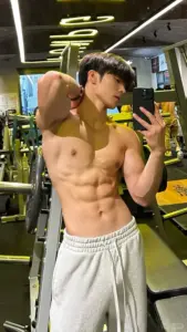Khoảnh khắc trong phòng gym trước gương, quần jogger sáng màu và dáng đứng tự tin khỏe