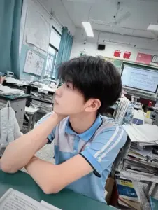 Ánh nhìn nghiêng trong lớp học, áo xanh trắng gọn gàng cùng mái tóc đen mượt