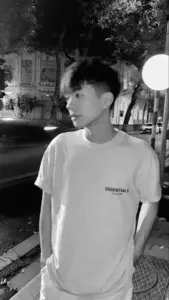 Khung ảnh đen trắng bắt trọn góc nghiêng chàng trai K9, áo trắng nhẹ và tóc bay