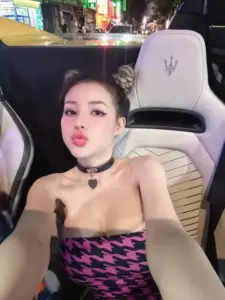 Bên trong xe sang, Ngân 98 chụp selfie với áo hai dây đen hồng và ánh mắt sắc