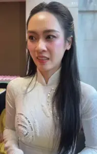Cận cảnh gương mặt thanh tú trong áo dài trắng, cô nhìn nghiêng, nét mặt điềm tĩnh