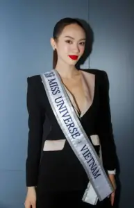 Với blazer đen khoét sâu và dải sash, cô tạo dáng studio bằng ánh nhìn sắc sảo