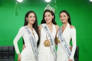 Ba cô gái đeo sash đứng cạnh nhau, Vũ Thúy Quỳnh mặc váy trắng và cười dịu