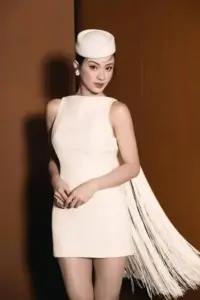 Chiếc váy trắng ngắn giúp bóng hồng thời trang khoe vai thon dưới phông nền nâu ấm