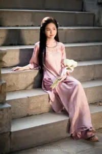 Nàng áo dài tím ngồi trên bậc thềm, ảnh áo dài dịu màu với bó hoa nhỏ