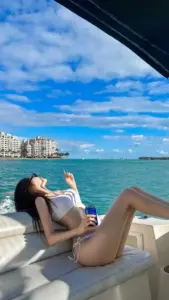 Đường cát resort, cô nàng mặc bikini đen khoác sơ mi mỏng, tóc xoăn thả nhẹ